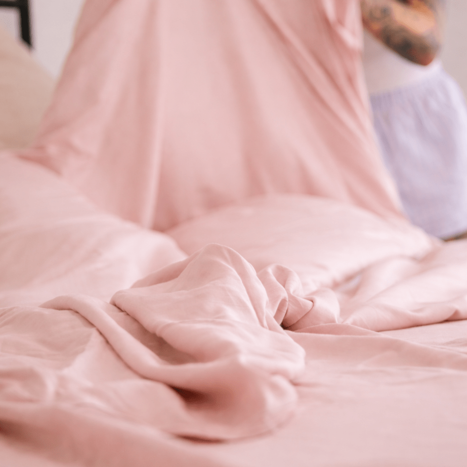 Close-up of light pink bamboo fabric with soft texture and natural draping.