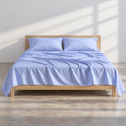 Blue striped top sheet displayed on light wood bed in bright bedroom setting