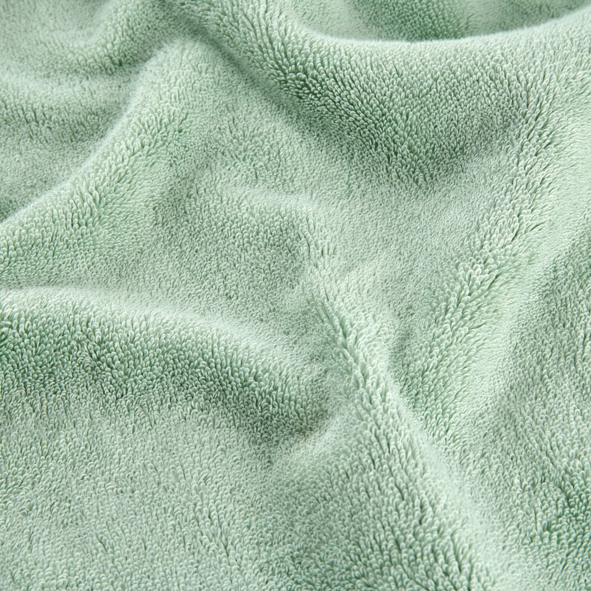 Green bamboo towel set showing soft textured fabric surface detail in close-up view