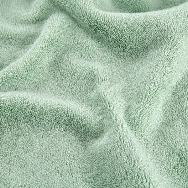 Juego de toallas de bambú verde mostrando detalle de textura suave del tejido en vista de cerca
