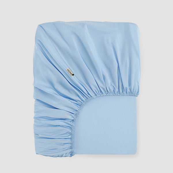 Sábana bajera ajustable Azul cielo Bambú by Momo Cotton – satén 300 hilos, suave, transpirable y sostenible.