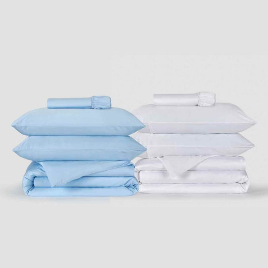 Dos juegos de funda nórdica lado a lado, uno azul claro y otro blanco, con fundas de almohada y sábanas ajustadas a juego