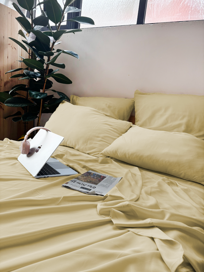 Cama com lençol de cima bege areia de bambú, almofadas – macio e sustentável