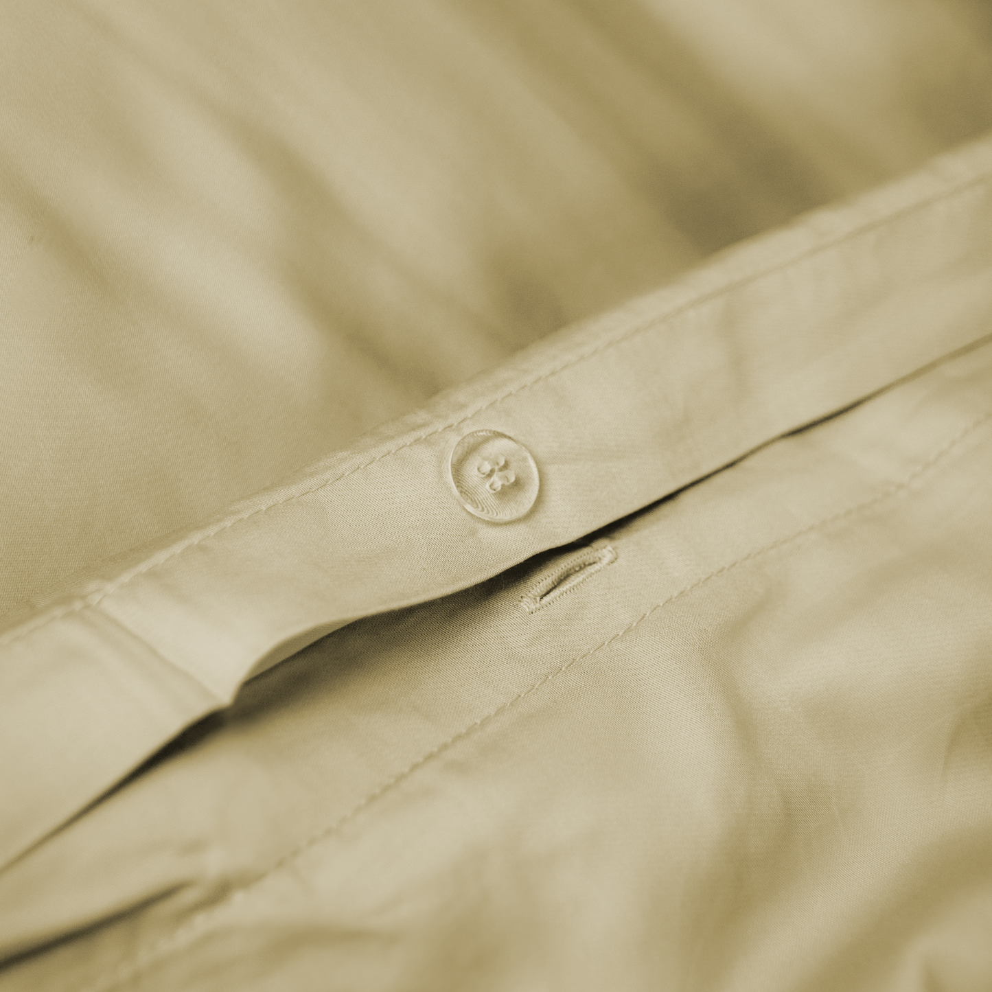 Close-up de capa de edredão de bambu bege areia com detalhe do botão de fecho – macia, sustentável e respirável