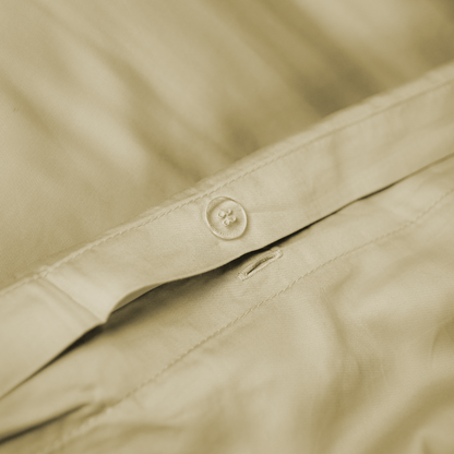 Close-up de capa de edredão de bambu bege areia com detalhe do botão de fecho – macia, sustentável e respirável