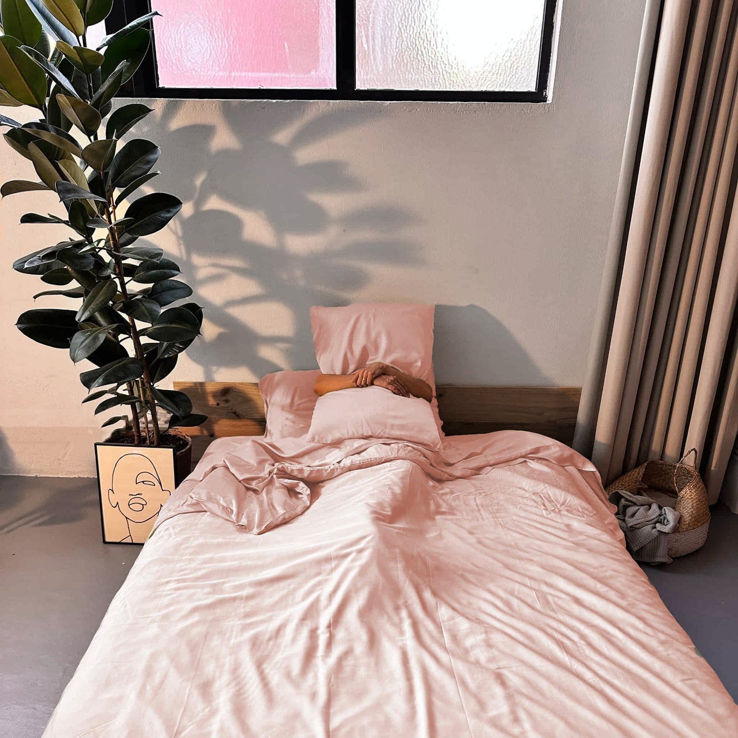 Complete bamboo bedding set in lemonade pink on bed with woman – soft, breathable and sustainable
