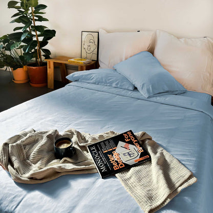 Light blue bamboo duvet with white pillows and magazine on bed – soft, breathable and sustainable bedding