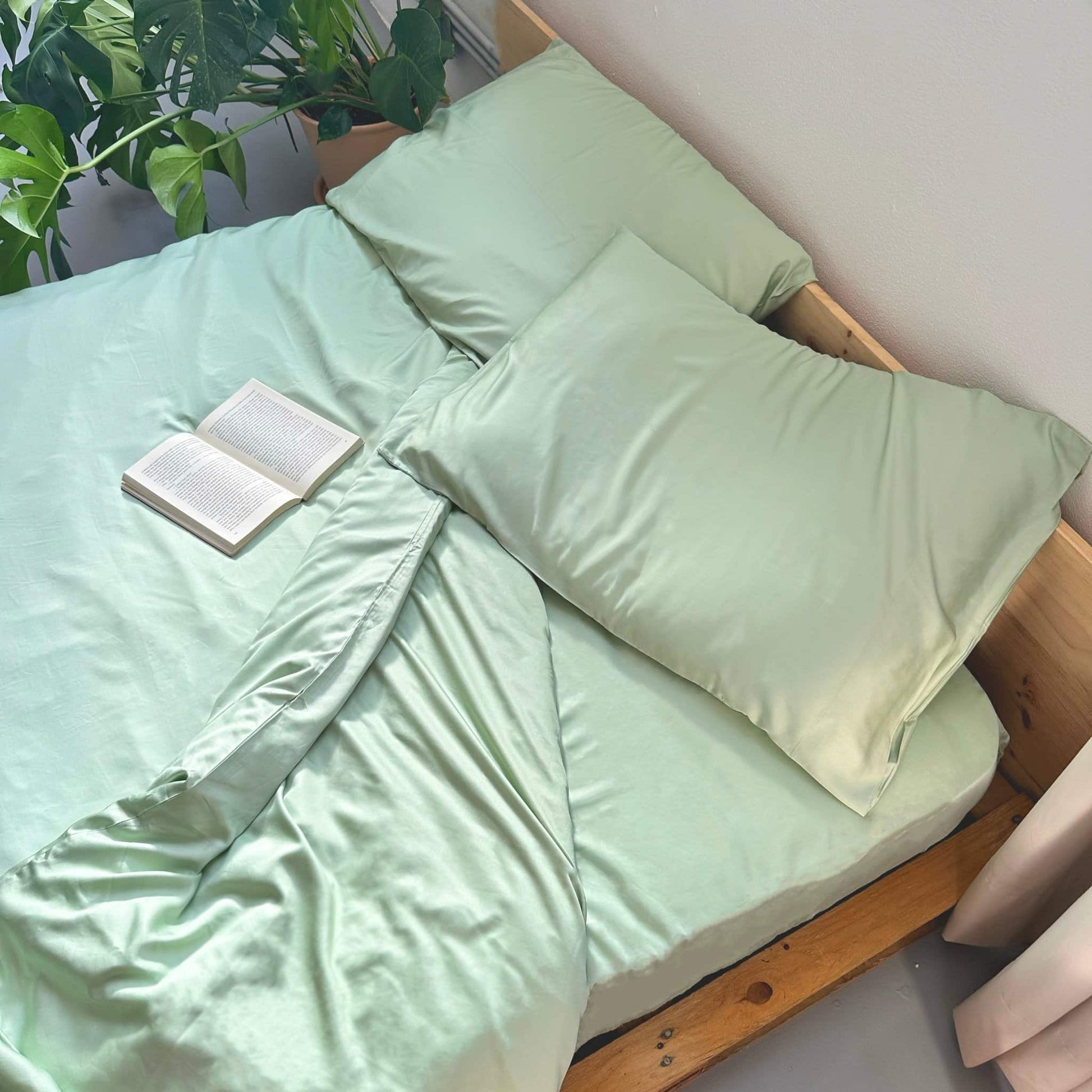 Top view of green bamboo duvet set with book – duvet and pillows, soft, breathable and sustainable bedding