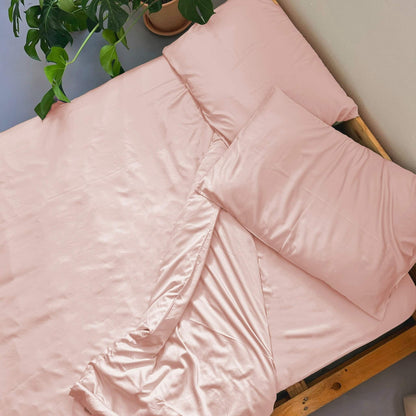 Pink bamboo duvet cover set with plant from above – soft, breathable and sustainable bedding for all seasons