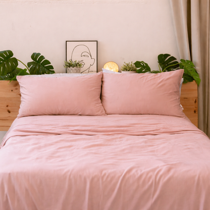 Soft pink bamboo bedding neatly made, highlighting the smooth and elegant drape of the fabric.