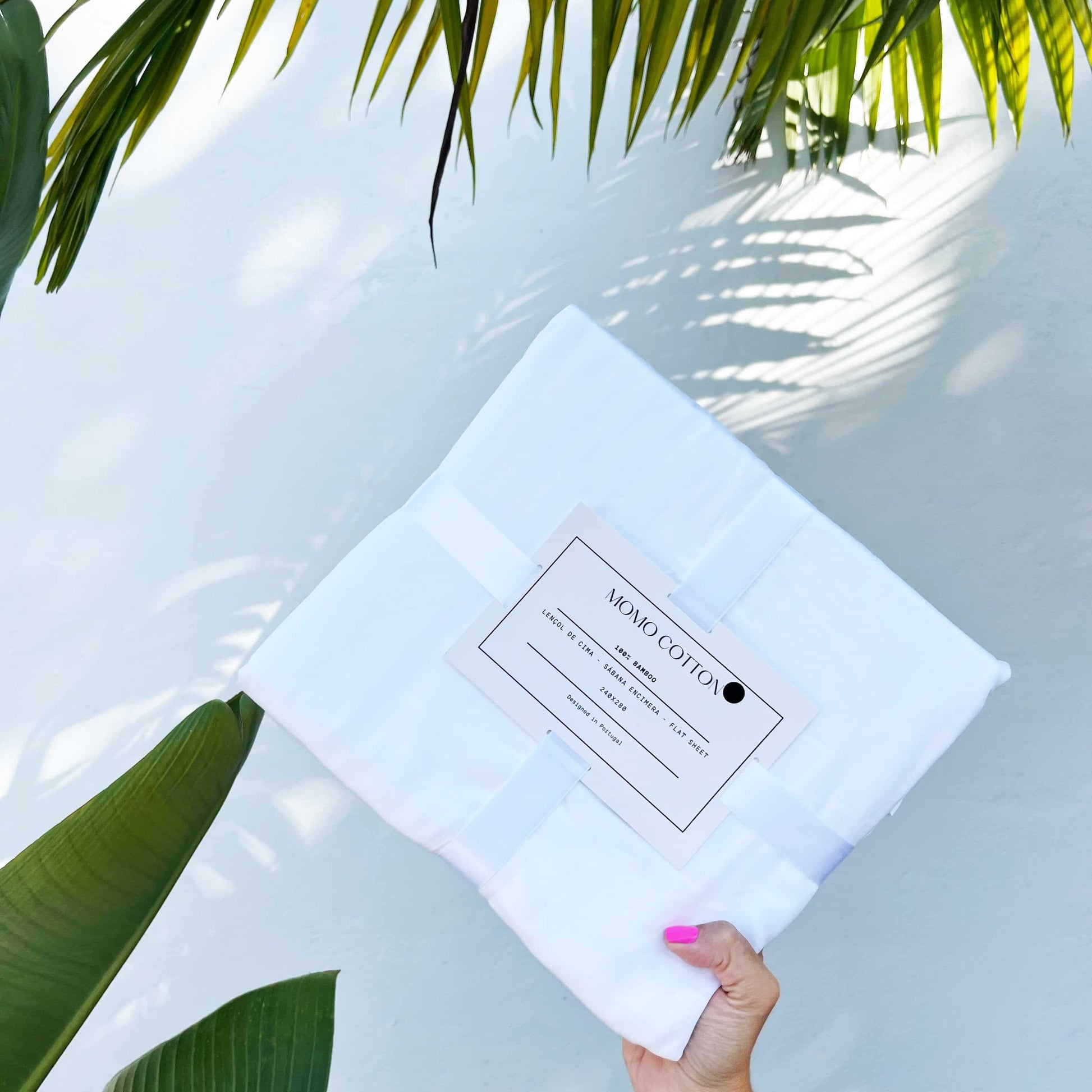  White bamboo flat sheet pack held by hand – soft, breathable and sustainable bedding