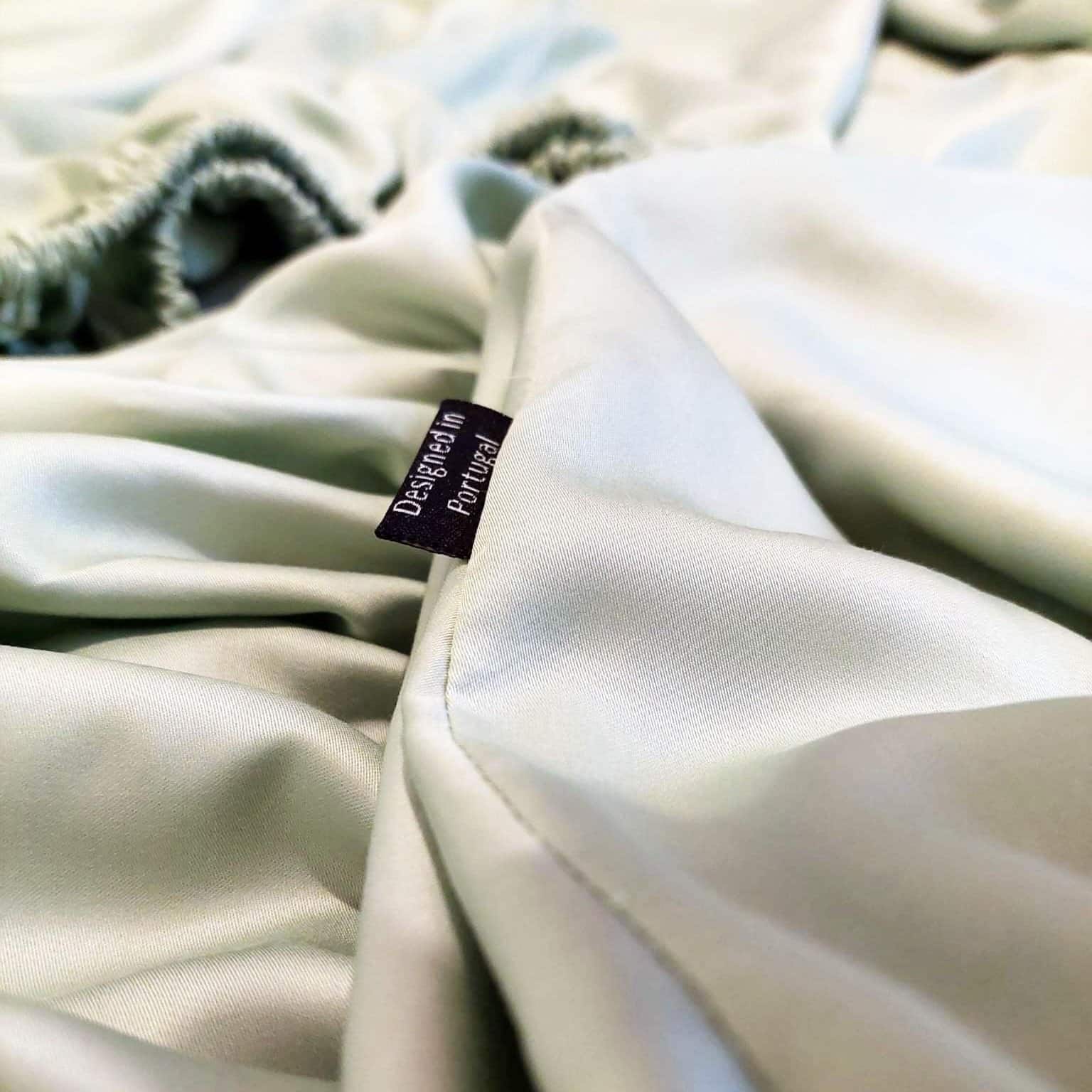 Close-up of green bamboo fitted sheet with design label – soft, breathable and sustainable bedding