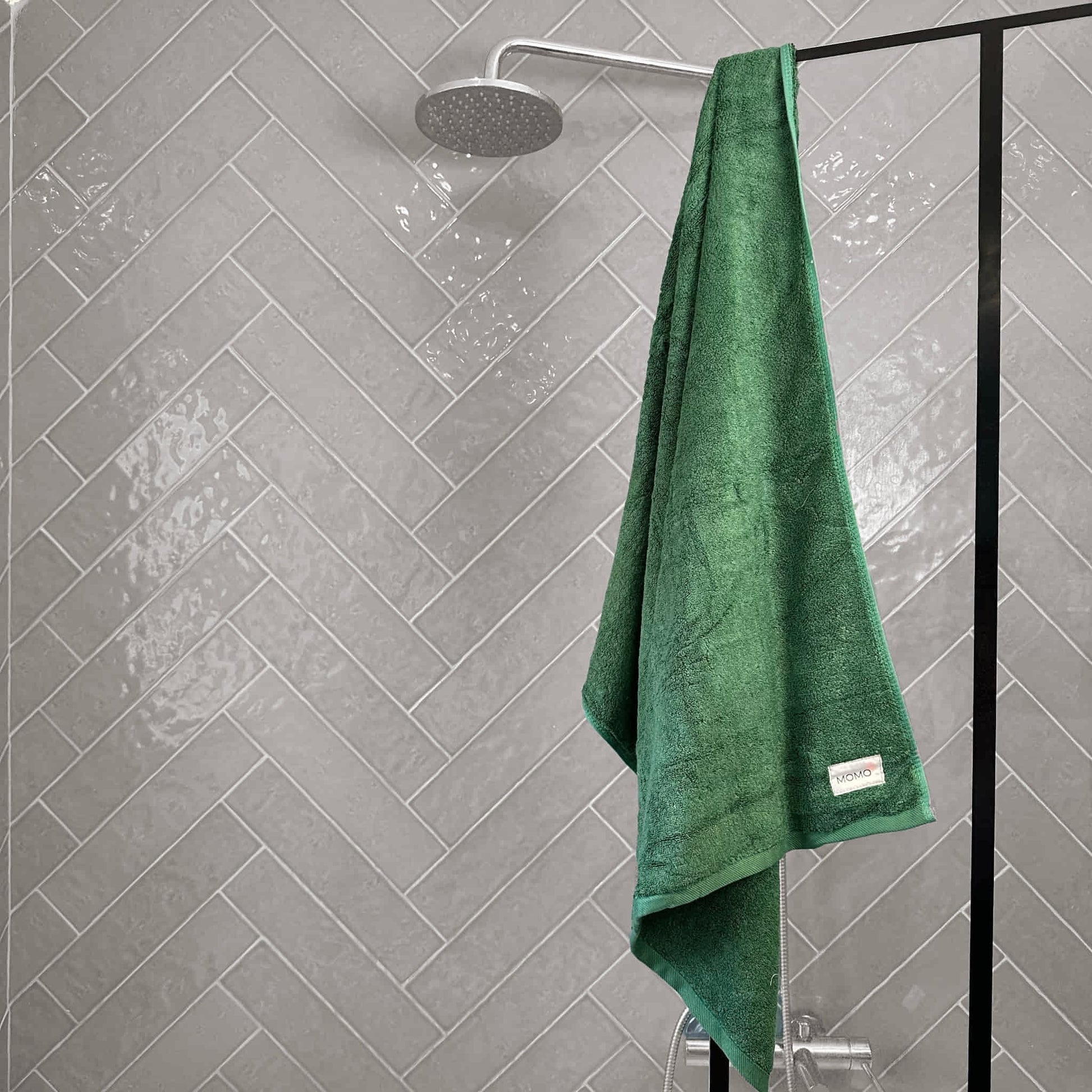 Green bamboo towel on grey background – soft, absorbent and sustainable