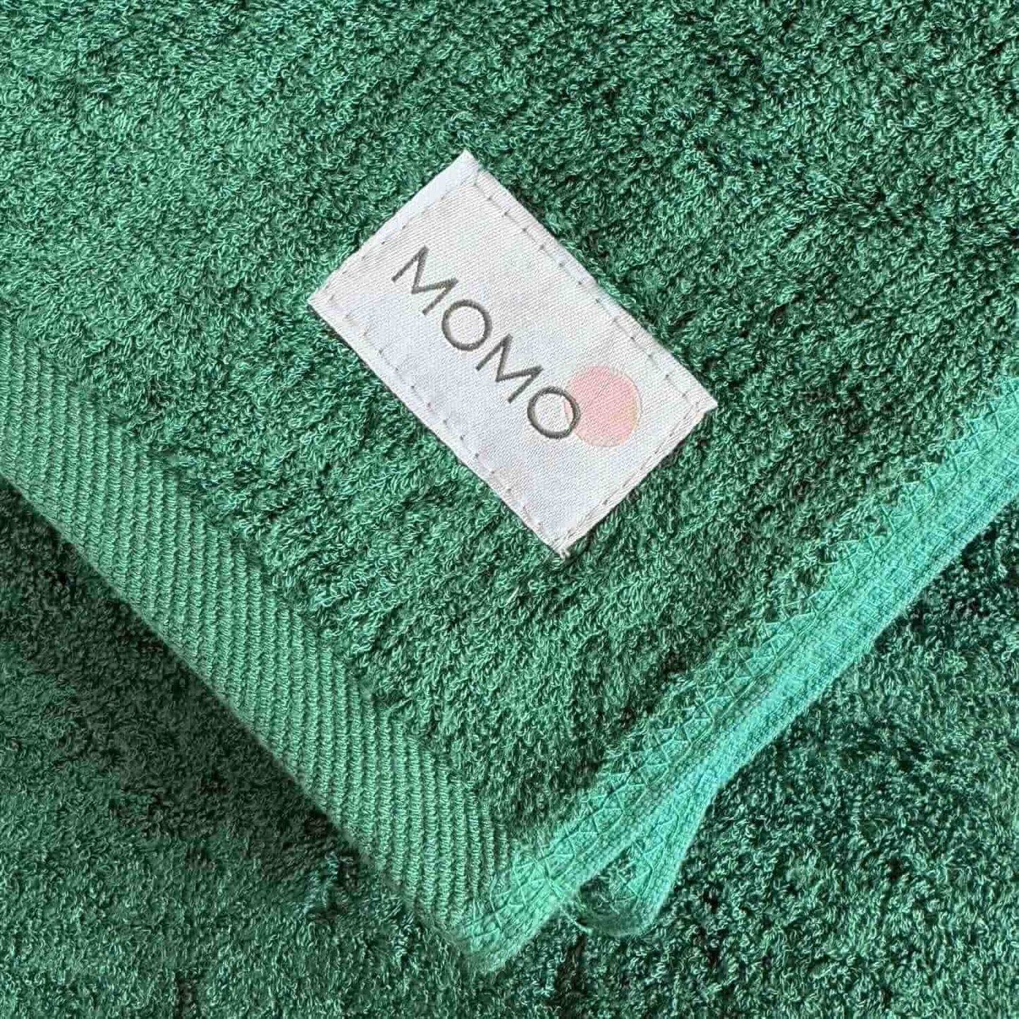 Closeup of green towel Momo bamboo label – sustainable, soft and premium quality detail