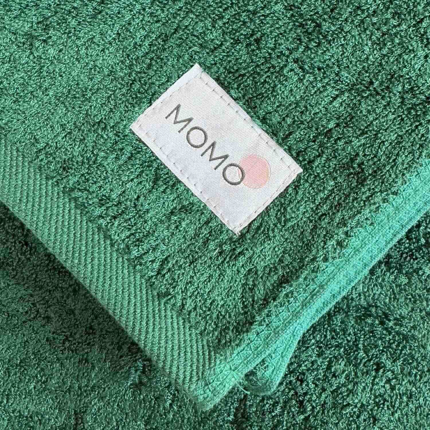 Closeup of green towel Momo bamboo label – sustainable, soft and premium quality detail