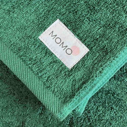 Closeup of green towel Momo bamboo label – sustainable, soft and premium quality detail
