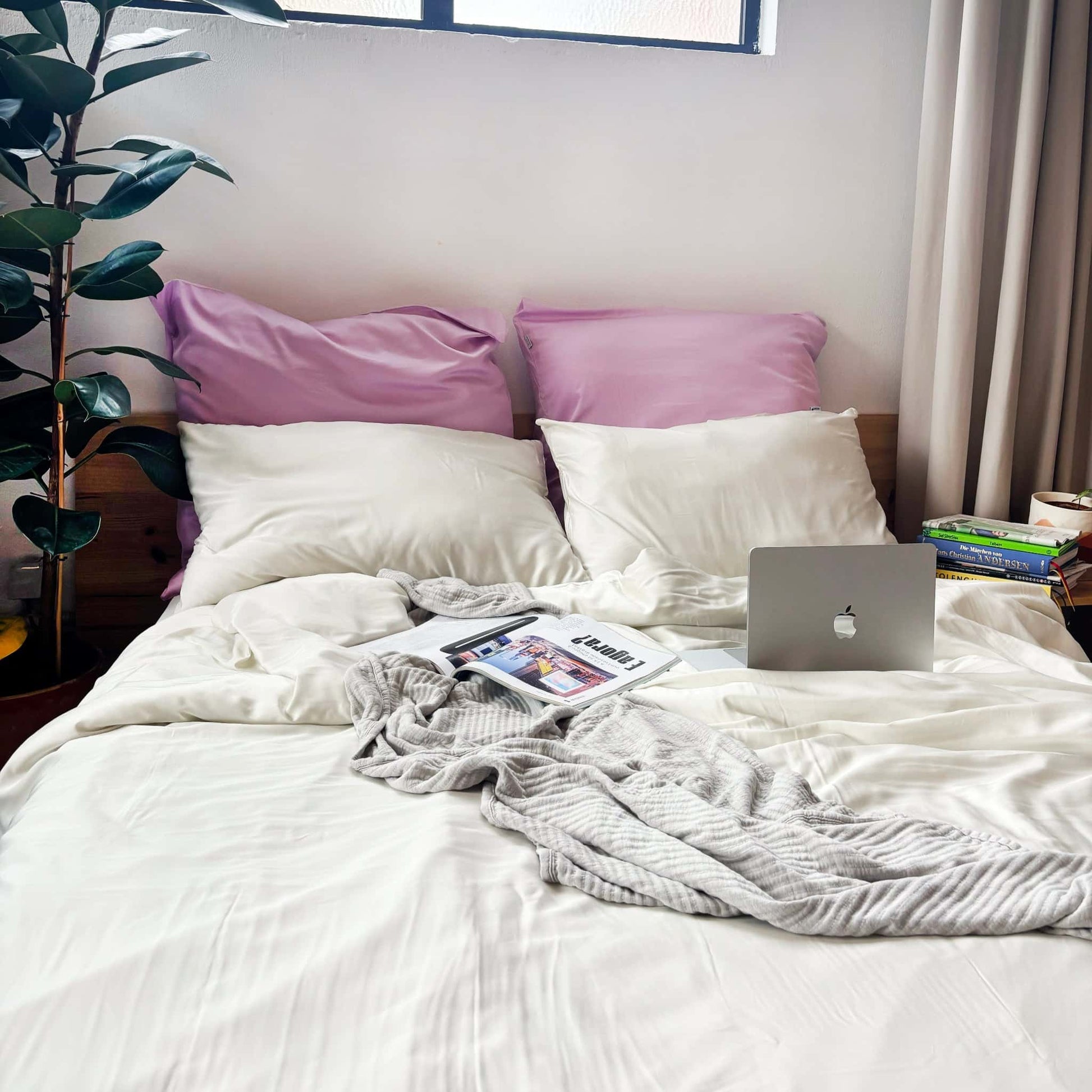 White, pearl and lilac bamboo duvet set with grey bamboo blanket on messy bed – soft, breathable and sustainable