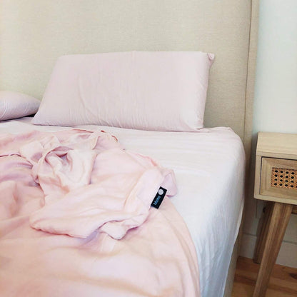 Pink bamboo bedding set on bed with side table – duvet, sheets and pillows, soft, breathable and sustainable