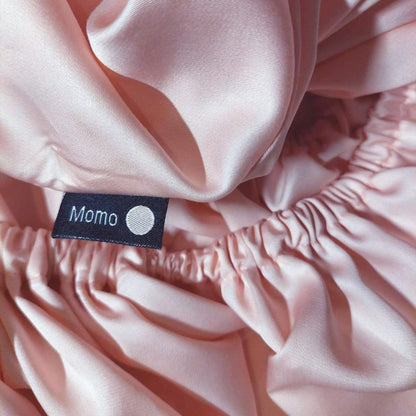 Close-up of tag on pink bamboo fitted sheet – soft, breathable and sustainable bedding