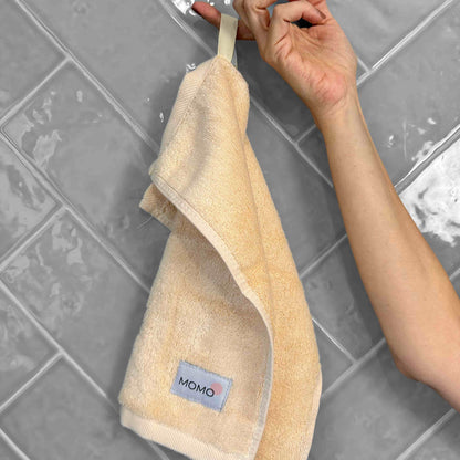 Beige bamboo washcloth on grey background – soft, absorbent and sustainable