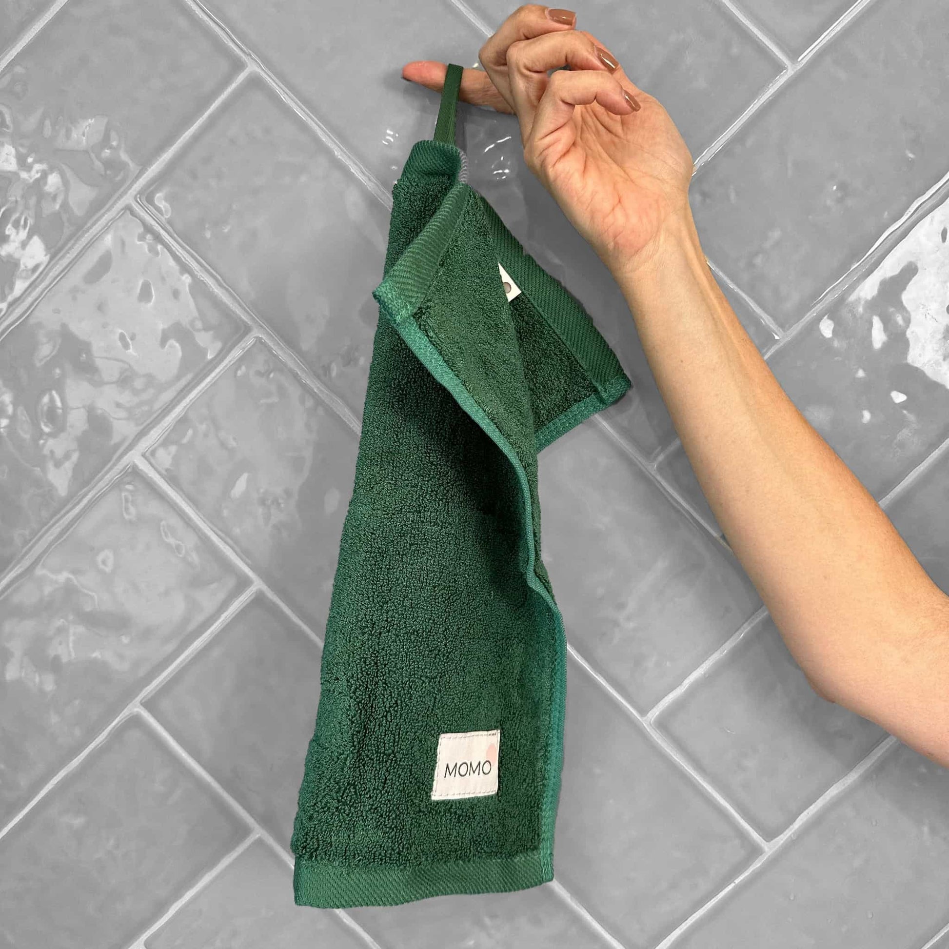 Green bamboo washcloth on grey background – soft, absorbent and sustainable