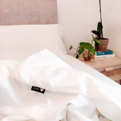 White bamboo duvet set on bed with side table – close-up of label, soft, breathable and sustainable bedding