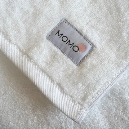 Close-up of Momo label on white bamboo towel – soft, absorbent and sustainable