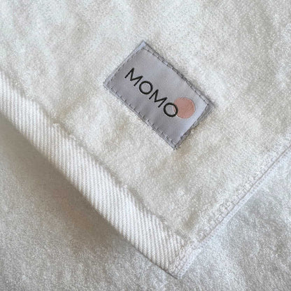 Close-up of Momo label on white bamboo towel – soft, absorbent and sustainable
